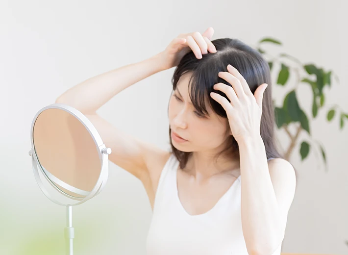 女性が鏡を見ている写真